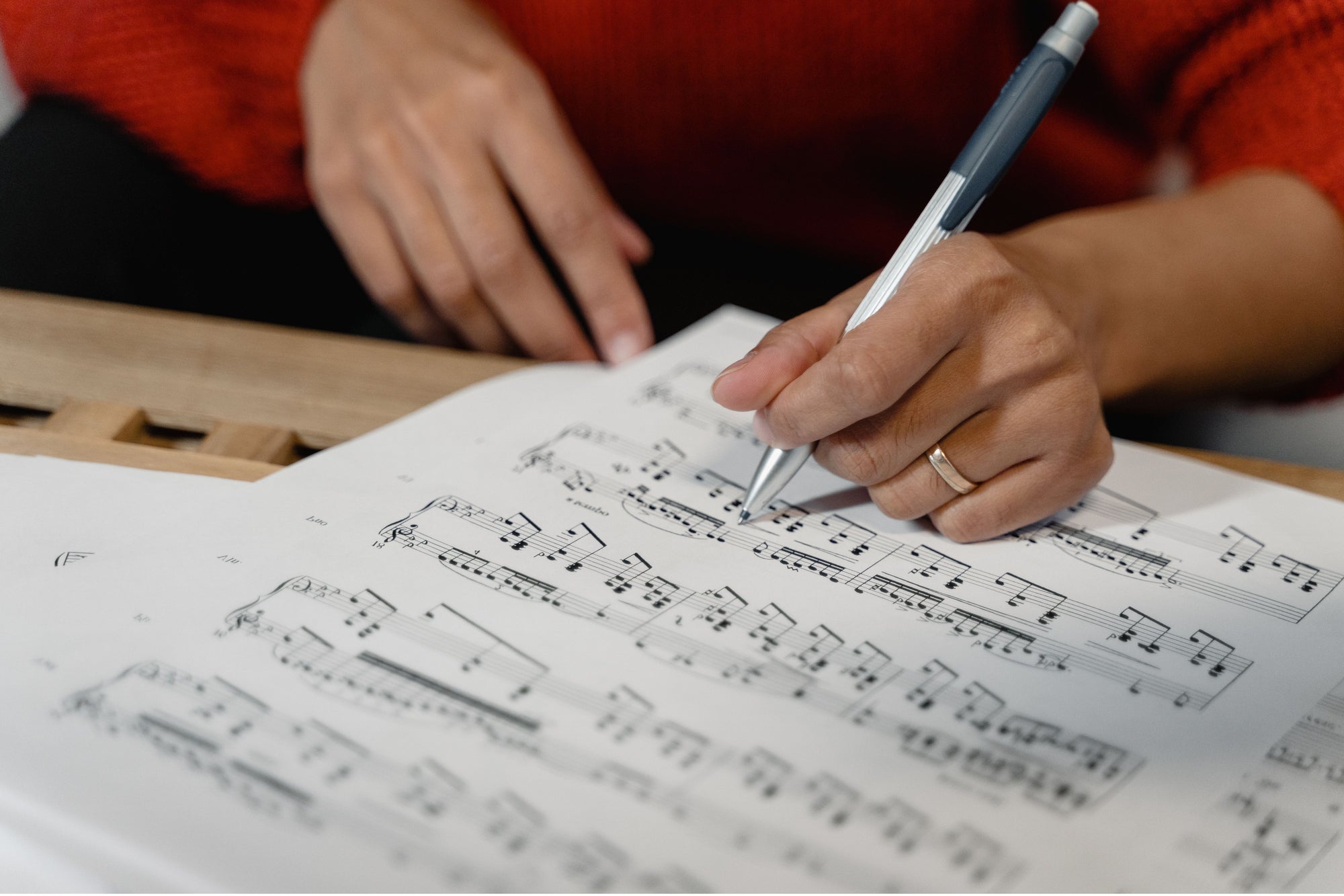 Close-up van de handen van een muzikant die bladmuziek schrijft